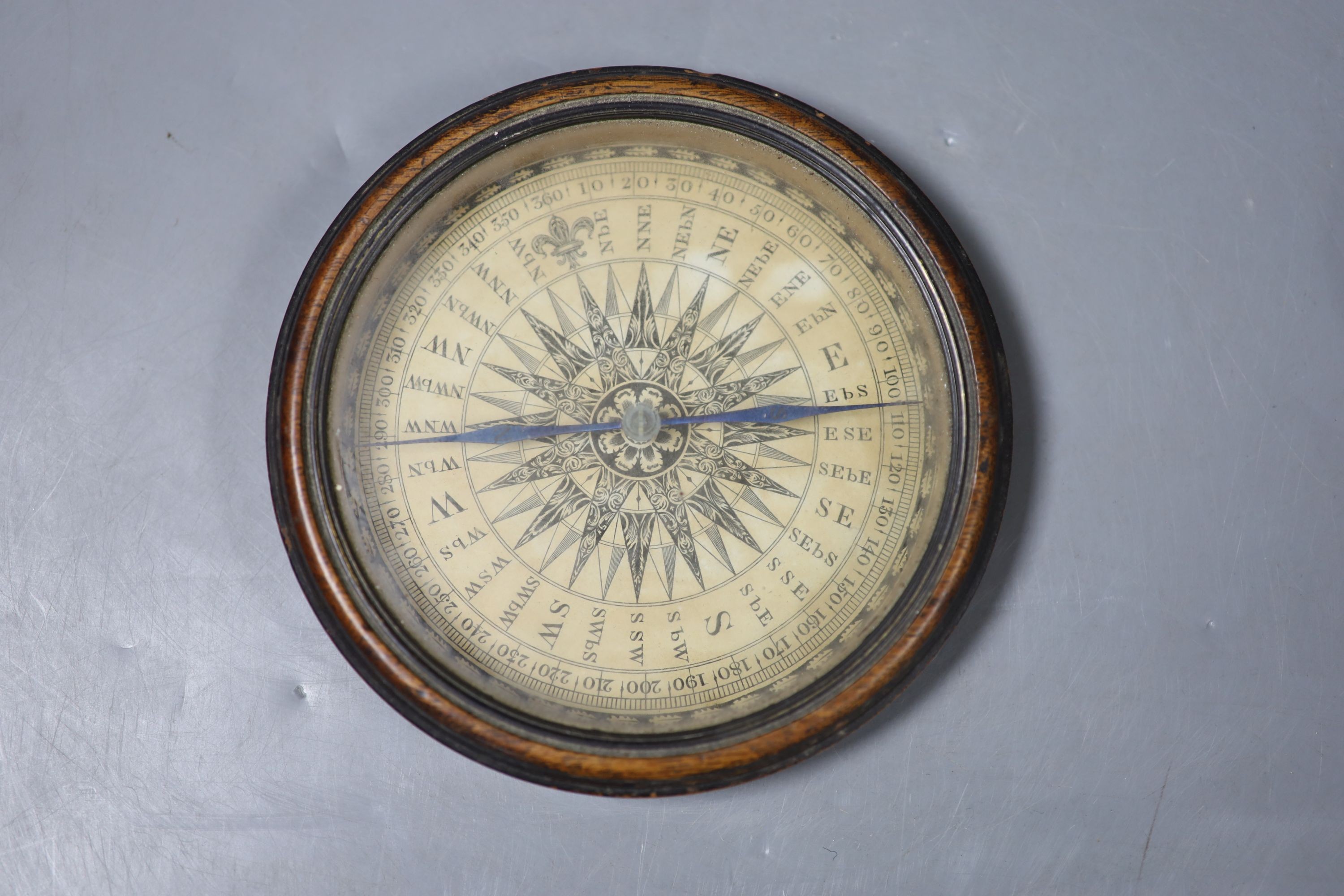 A 19th century circular papier mache box and cover decorated with cherubs and a compass from a library globe, diameter 14cm